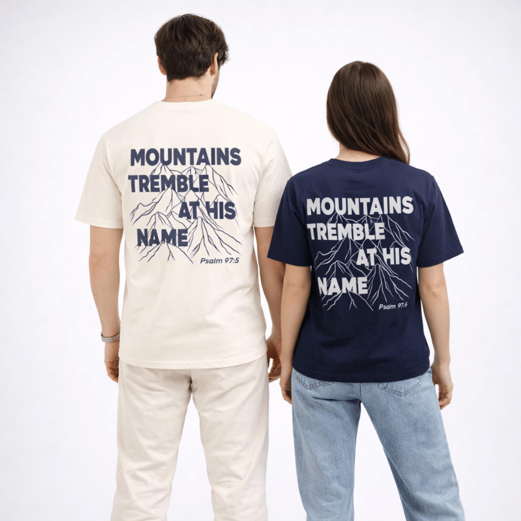 Two people wearing t-shirts with 'Mountains Tremble at His Name' text on the back.