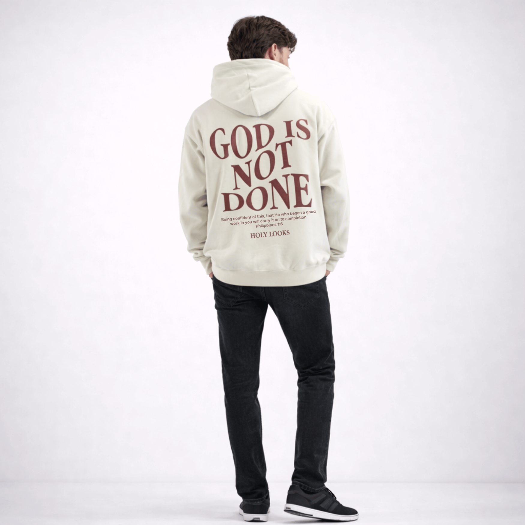 Person wearing a hoodie with 'God is Not Done' text on the back, standing against a white background
