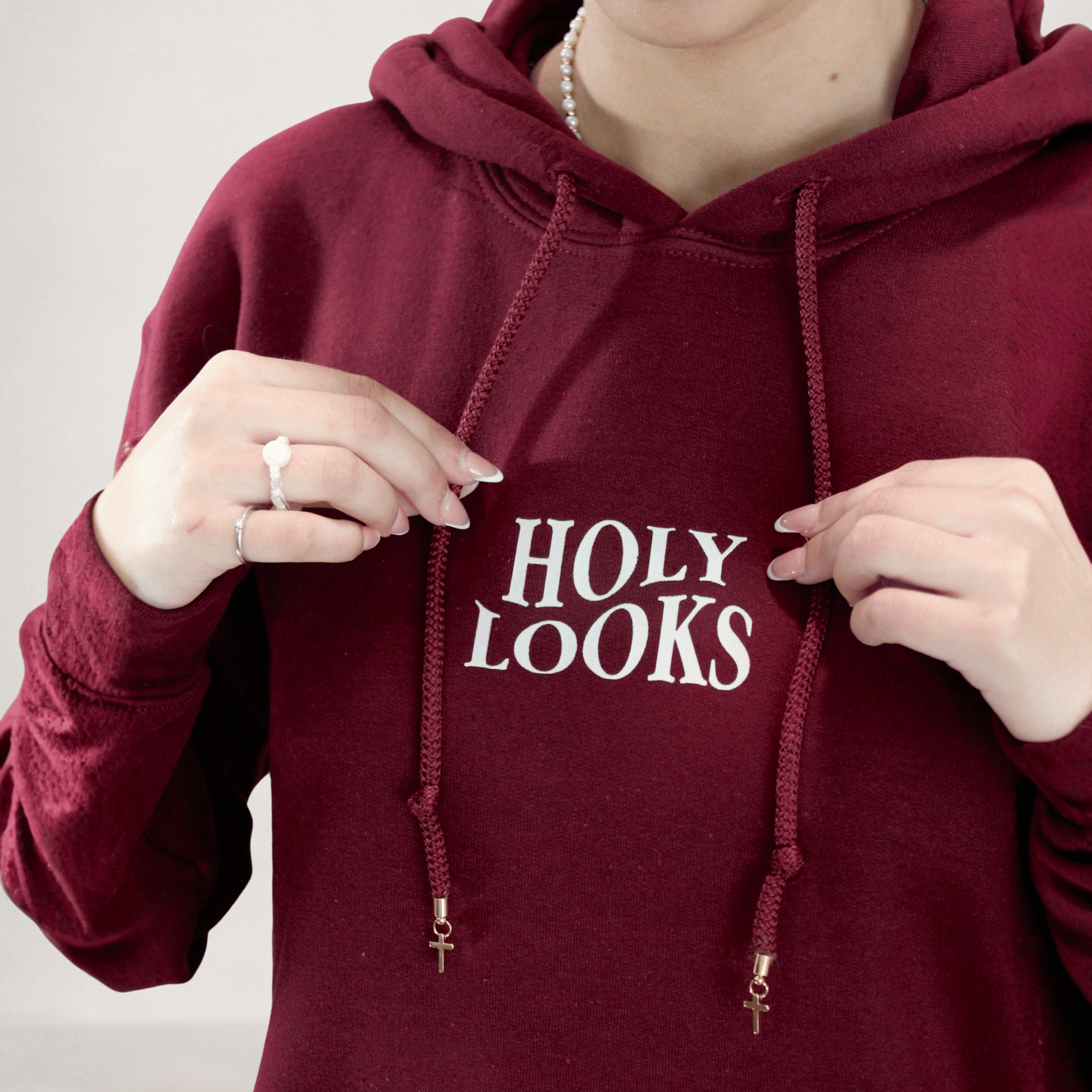 Maroon hoodie with 'HOLY LOOKS' text on a plain background