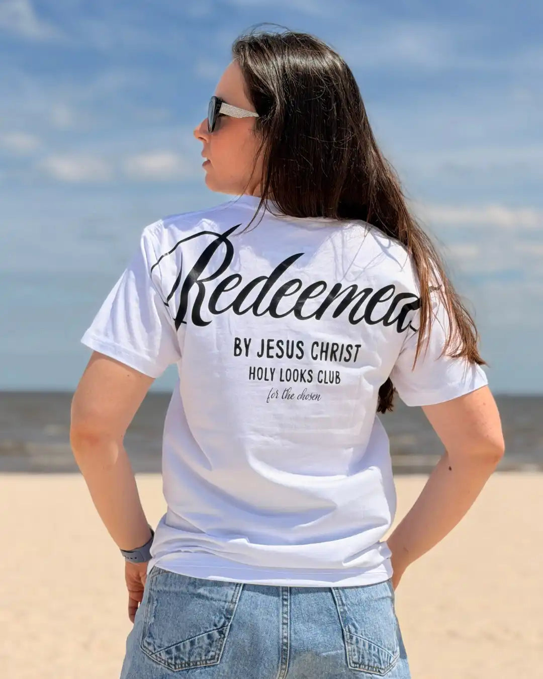 Woman wearing a white t-shirt with text on the beach