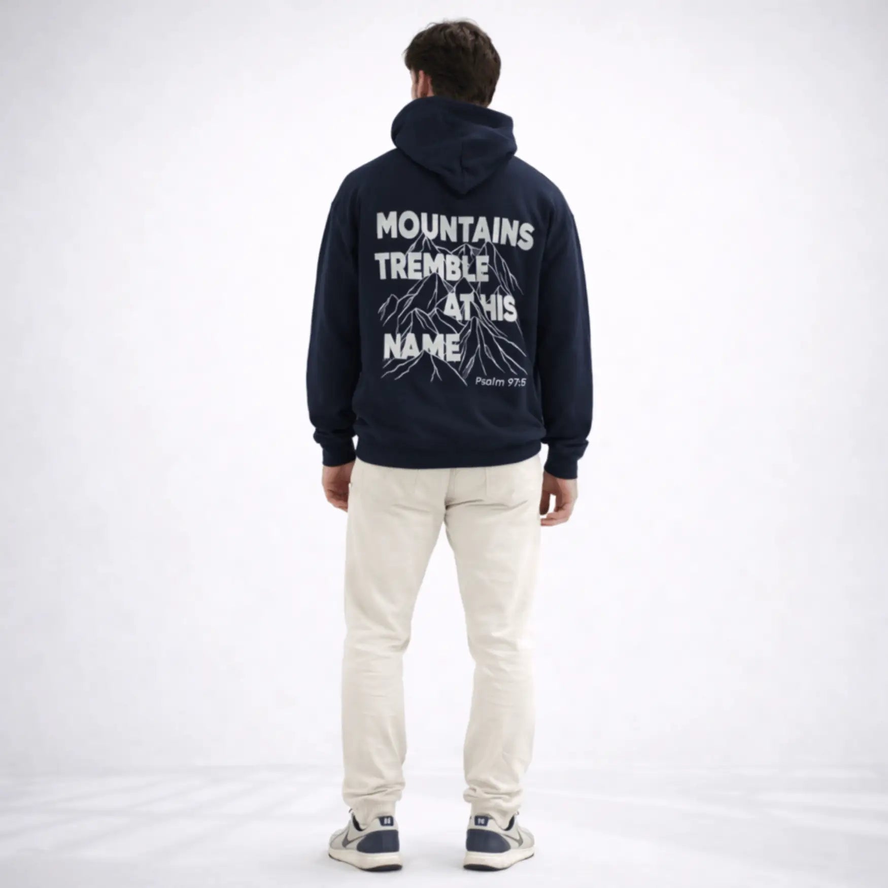 Person wearing a navy hoodie with text on the back, standing against a white background