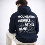 Person wearing a navy hoodie with mountain design and text on the back