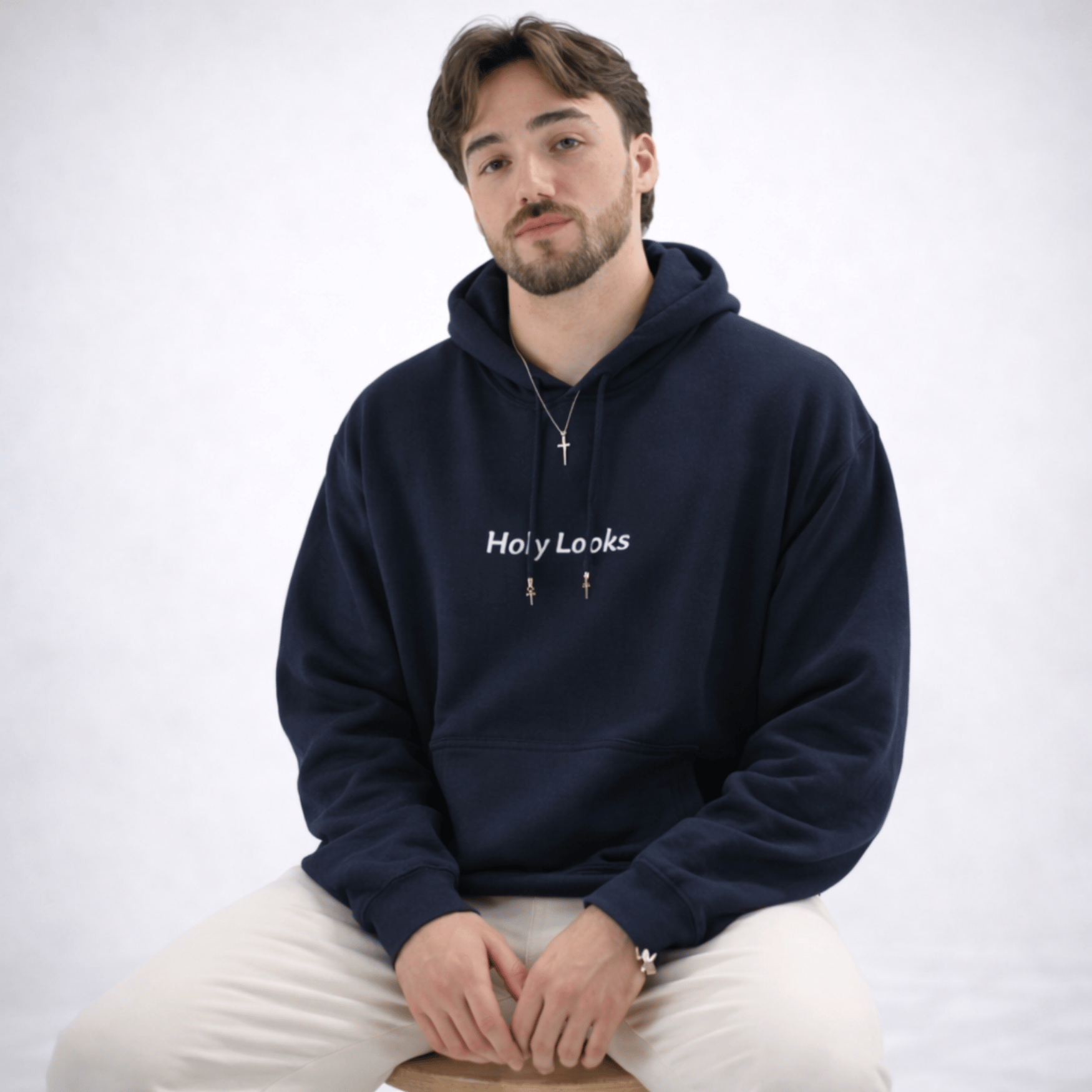 Man wearing a navy blue hoodie with 'Holy Looks' text on a white background