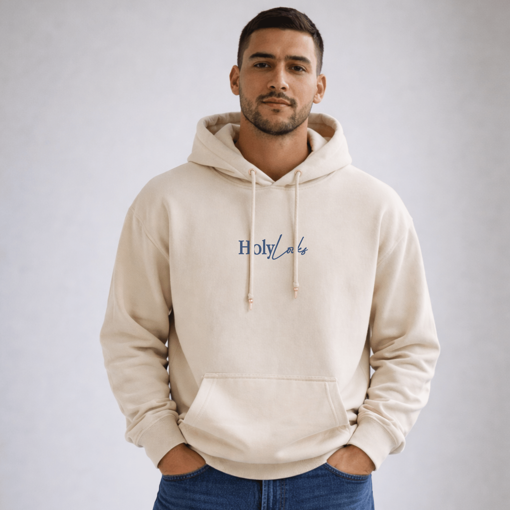 Man wearing a beige hoodie with 'Holy Lake' text on a plain background