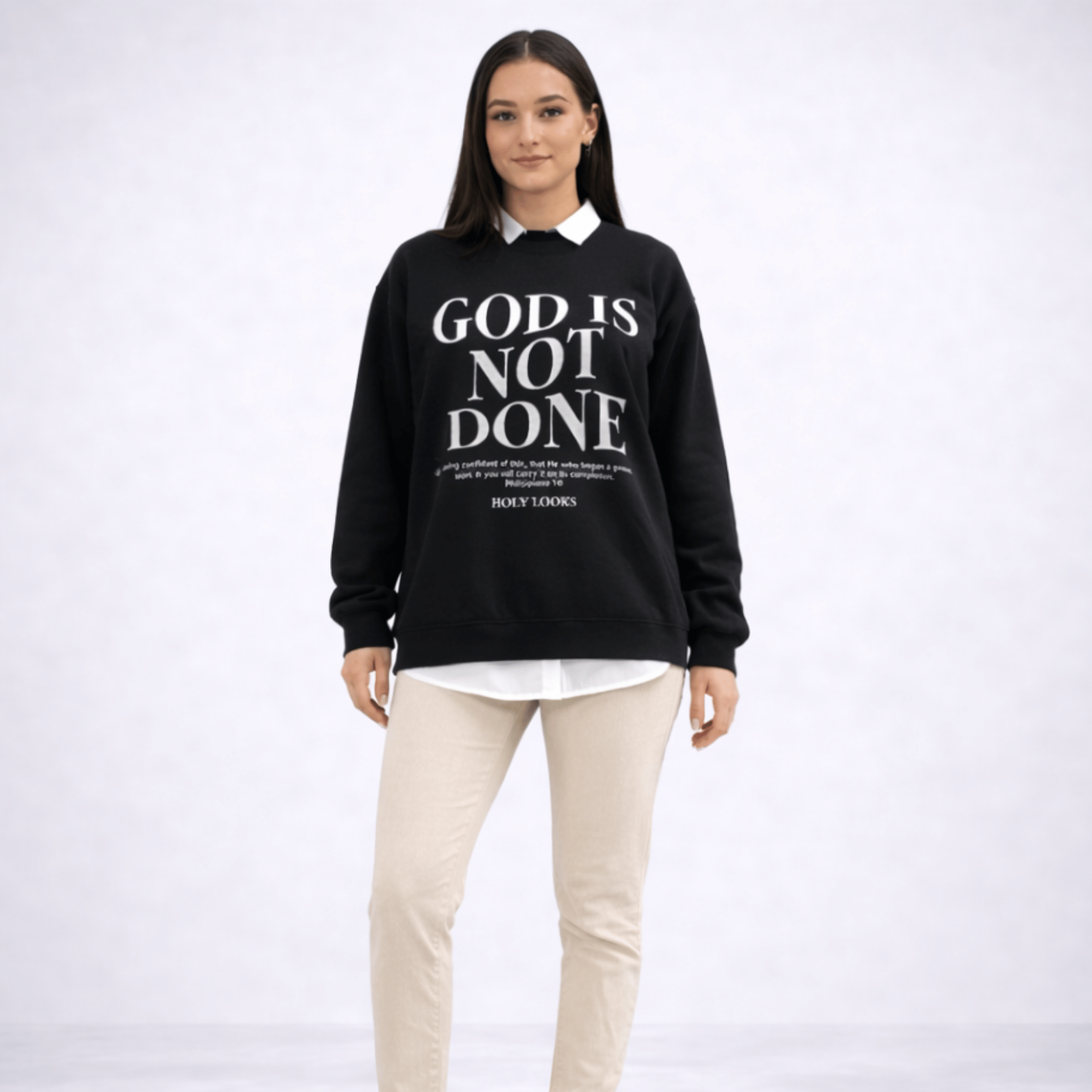 Person wearing a black sweatshirt with 'God is not done' text on a white background