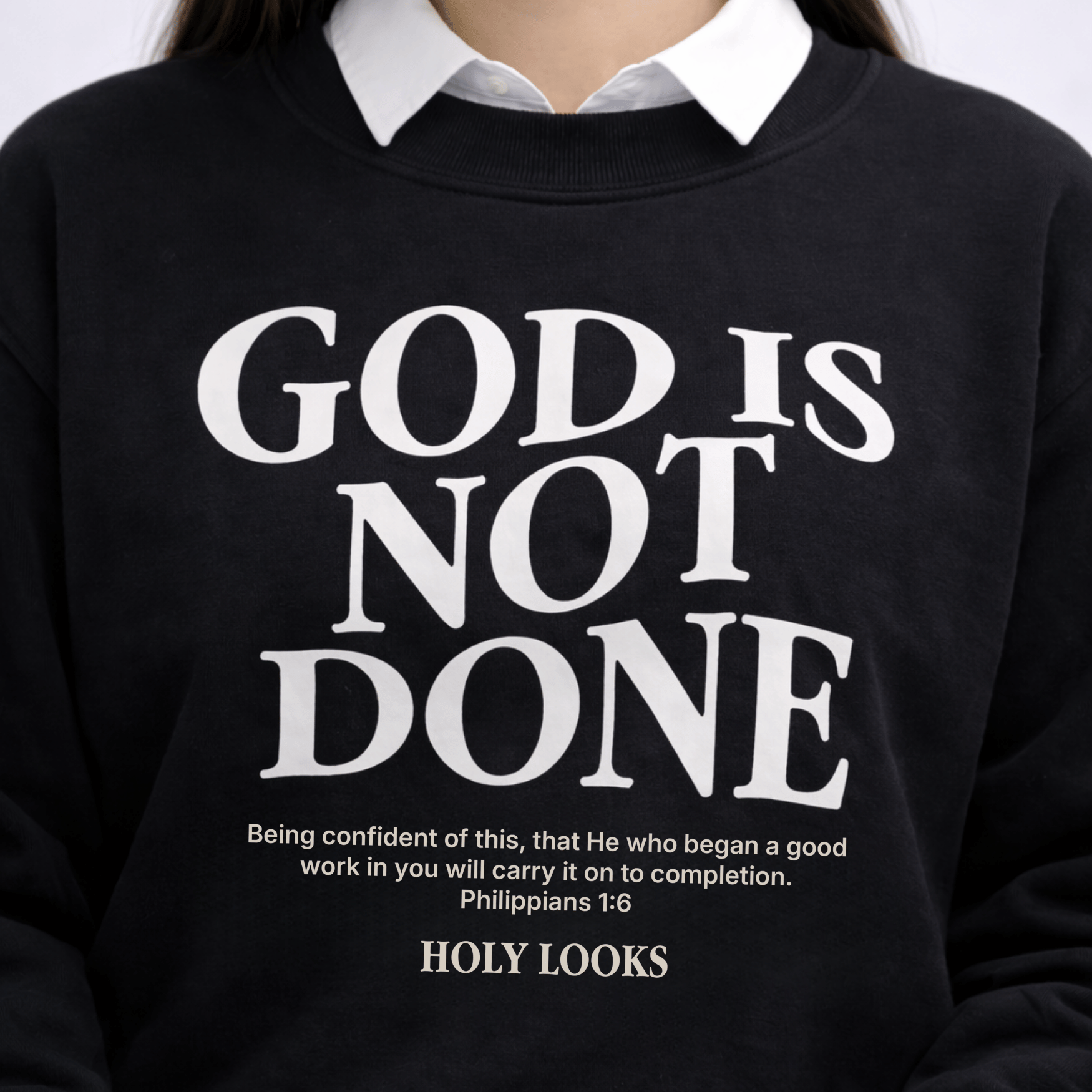 Black sweatshirt with 'GOD IS NOT DONE' text and 'HOLY LOOKS' branding.