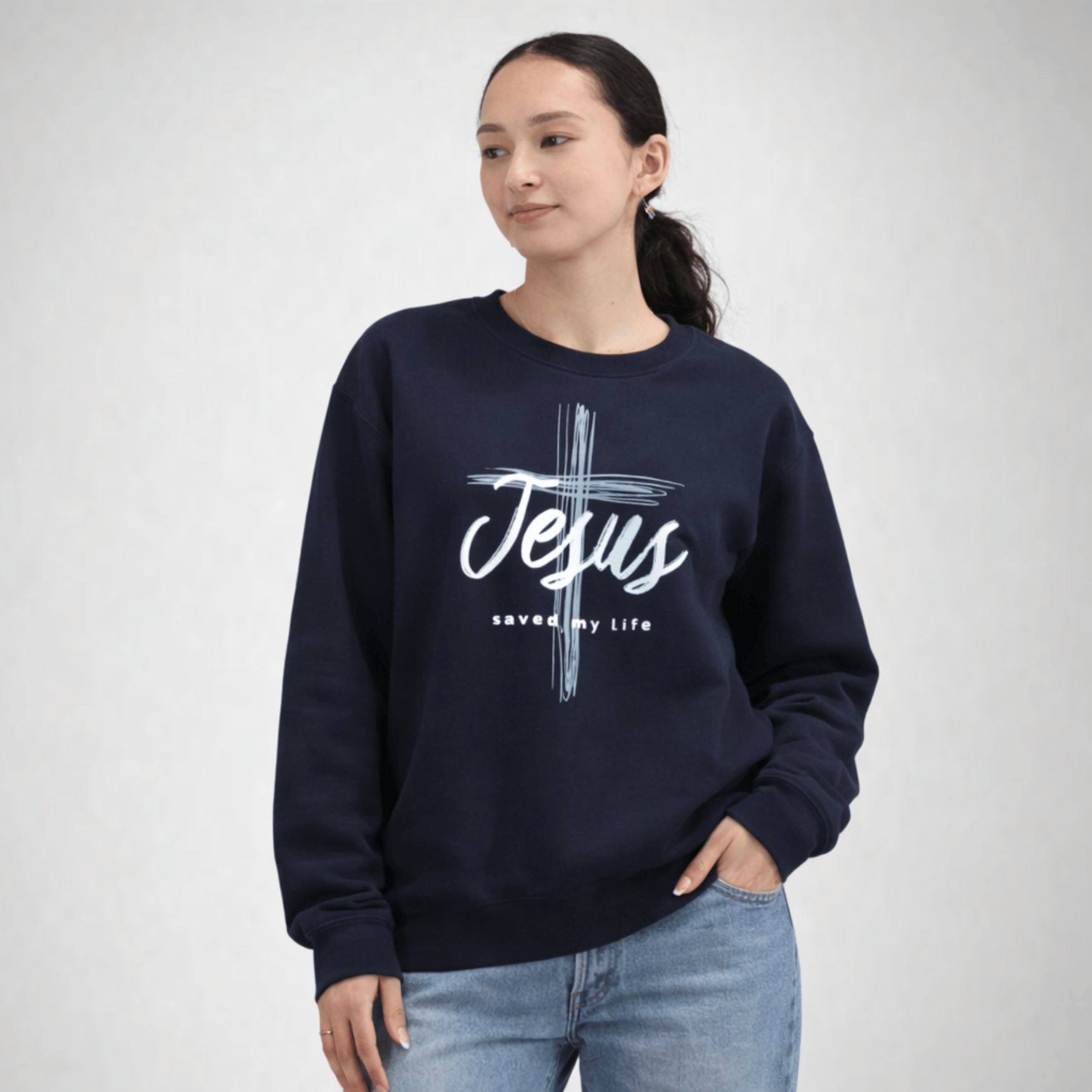 Person wearing a navy blue sweatshirt with 'Jesus saved my life' text on a white background